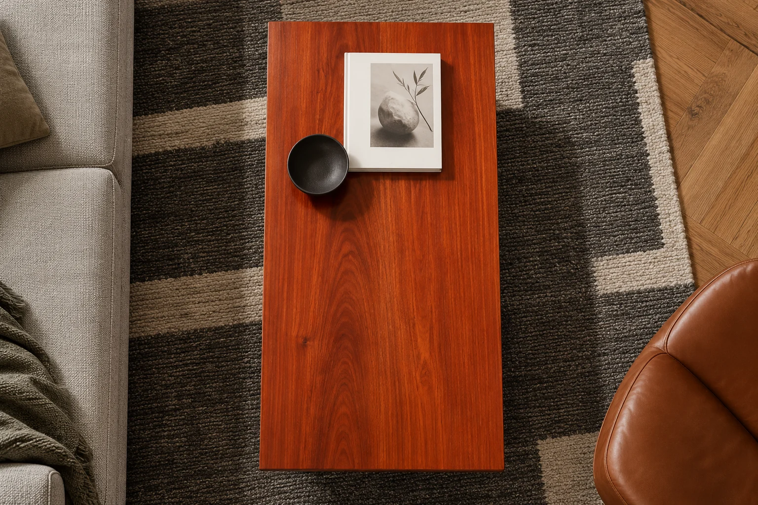 Overhead view of the padauk coffee table with a book and a dark ceramic bowl